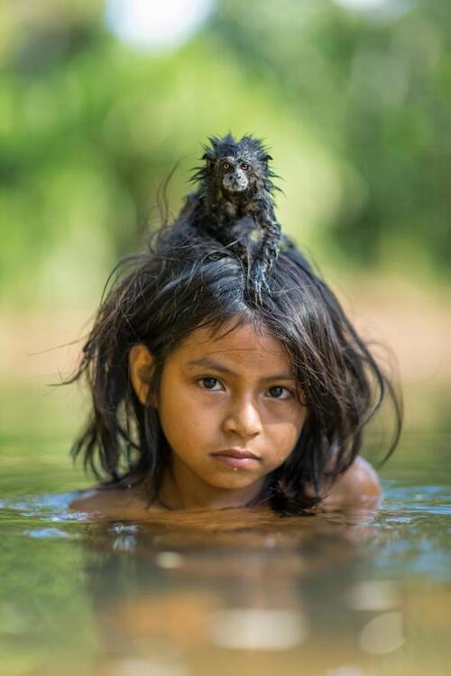 Une petite fille Marsigenka et son tamarin apprivoisé