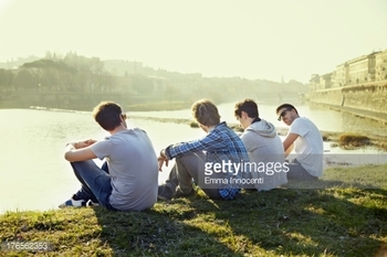 176562353-group-of-friends-sitting-along-the-river-gettyimages
