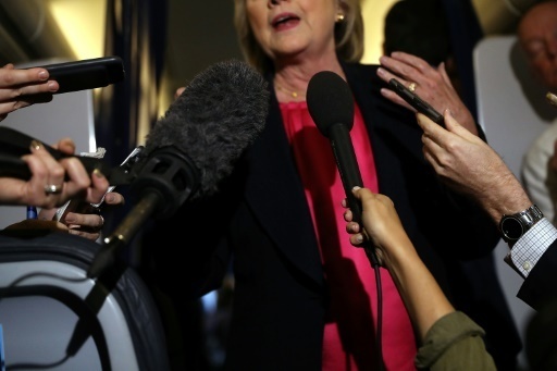 Des journalistes tendent des micros devant la candidate démocrate à l'élection présidentielle, Hillary Clinton, à bord de son avion de campagne, le 6 septembre 2016