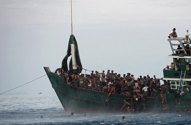 Des réfugiés rohingyas se jettent à l'eau pour recueillir des vivres larguées par un hélicoptère militaire thaïlandais en mer d'Andaman, le 14 mai 2015 (AFP / Christophe Archambault) Des réfugiés rohingyas se jettent à l'eau pour recueillir des vivres larguées par un hélicoptère militaire thaïlandais en mer d'Andaman, le 14 mai 2015 (AFP / Christophe Archambault)