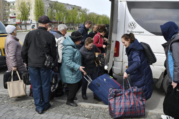Des personnes montent à bord de véhicules pour se rendre dans la ville ukrainienne de Dnipro lors d’une évacuation de civils à Kramatorsk, en Ukraine, mardi 19 avril 2022.