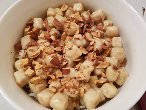 Cubes de TOFU croustillants enrobés de sauce à la mayonnaise, lait condensé & miel, parsemés d'amandes rôties