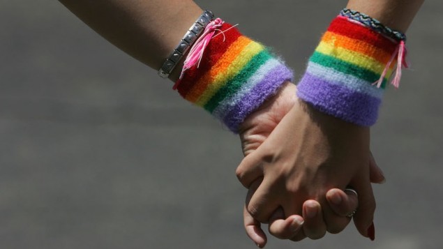 Un couple de lesbiennes se tient la main durant la marche des Fiertés de Tel Aviv le 3 juin 2016 (Crédit : David Silverman/Getty Images via JTA, File)