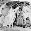 Two Apache women outside of a wickiup in Arizona