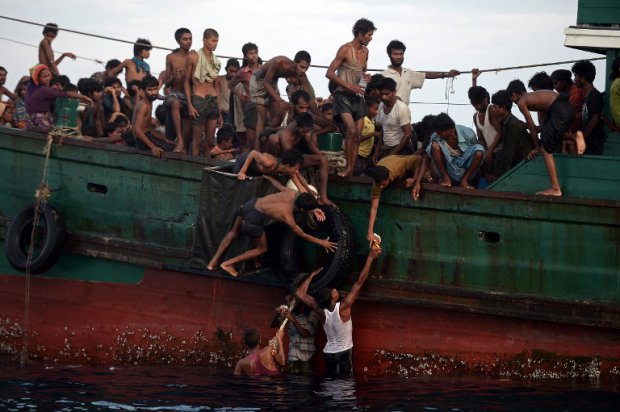Des réfugiés rohingyas recueillent de la nourriture larguée par un hélicoptère thaïlandais en mer d'Andaman, le 14 mai 2015 (AFP / Christophe Archambault) Des réfugiés rohingyas recueillent de la nourriture larguée par un hélicoptère thaïlandais en mer d'Andaman, le 14 mai 2015 (AFP / Christophe Archambault)