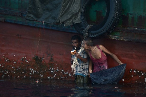 Des réfugiés rohingyas mangent de la nourriture larguée par un hélicoptère thaïlandais en mer d'Andaman, le 14 mai 2015 (AFP / Christophe Archambault) Des réfugiés rohingyas mangent de la nourriture larguée par un hélicoptère thaïlandais en mer d'Andaman, le 14 mai 2015 (AFP / Christophe Archambault)