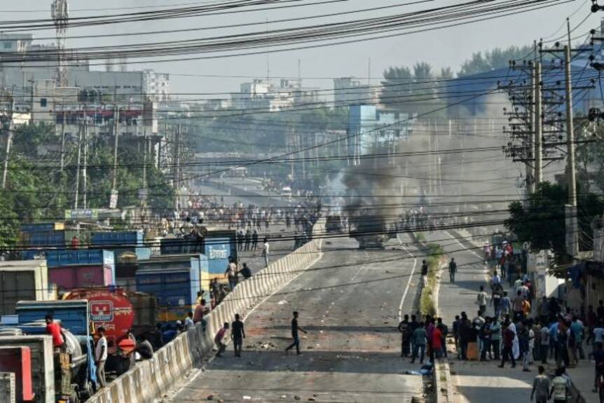 Un axe de circulation bloqué par un camion en feu au cours de manifestations d'ouvrier du textile exigeant de meilleurs salaires, à Shafipur, au Bangladesh, le 31 octobre 2023 ( AFP / Munir uz zaman )