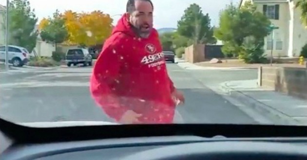Homme en rouge devant voiture