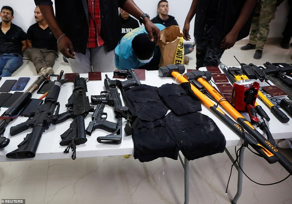 Des armes, des téléphones portables, des passeports et d'autres objets sont montrés aux médias avec les suspects de l'assassinat