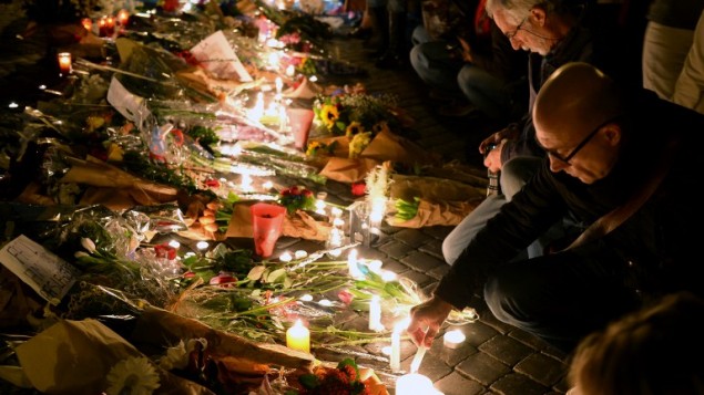 Les gens allument des bougies et déposent des fleurs, le 14 novembre, 2015 au mémorial de fortune devant l'ambassade française à Rome après une série d'attaques coordonnées dans et autour de Paris le 13 novembre (Crédit : AFP PHOTO / VINCENZO PINTO)
