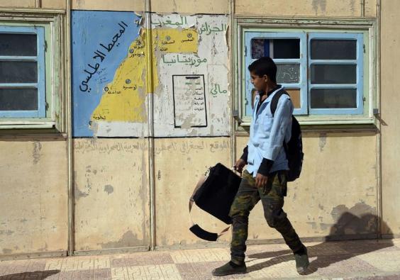 FAROUK BATICHE / AFP Un étudiant passe devant une carte du Sahara occidental, dans le camp de réfugiés sahraouis à Tindouf, dans le sud de l'Algérie.