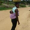 Congolaise avec son enfant au dos et sur la tête son contenant à eau
