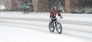 walking bicycle snowy winter city 