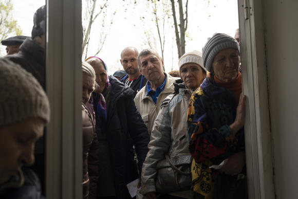 Des personnes attendent la distribution de nourriture et de médicaments, à Kramatorsk, oblast de Donetsk, en Ukraine, le mardi 19 avril 2022.