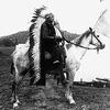 Chief Quanah Parker in Comanche war costume on horse.
