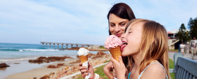 jeune femme et fillette mangeant une glace en bord de mer