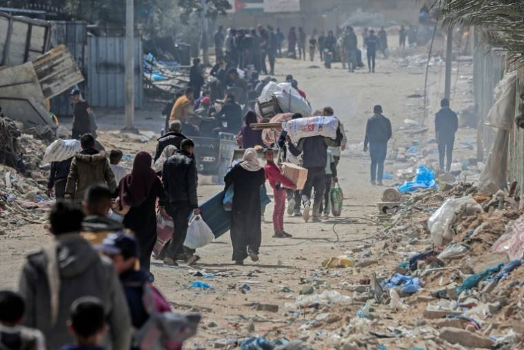Des Palestiniens déplacés transportent leurs affaires dans une rue de Khan Younès, dans le sud de la bande de Gaza, le 6 mars 2024 ( AFP / - )