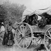 1882 - Native American (Navajo) women and children pose on and near a covered wagon