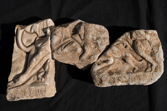 Denis Gliksman/ Inrap. Fragments d’une stèle en bas-relief représentant le sacrifice du taureau par Mithra, retrouvée à Lucciana.
