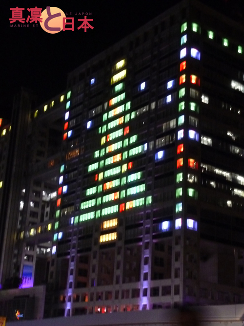 Un immeuble représentant un sapin de Noël en lumière 