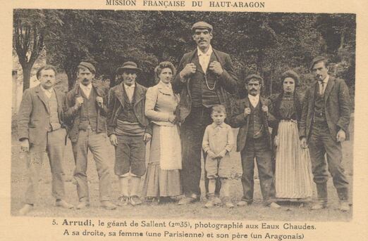 Peut être une image de 7 personnes et texte qui dit ’M SSION FRANÇAISE DU HAUT-ARAGON 5.Arrudi, le géant de Sallent (2m35), photographié aux Eaux Chaudes. A sa droite, sa femme (une Parisienne) et son père (un Aragonais)’