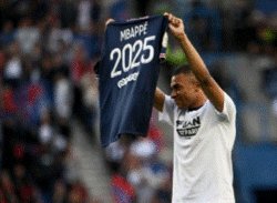 Kylian Mbappé tenant dans ses bras un maillot du PSG