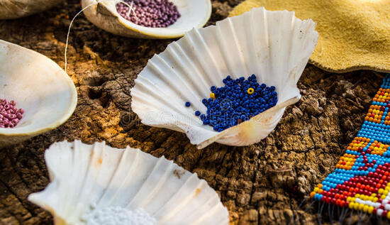 Perlage amérindien.  Les perles amérindiennes sont organisées en coquillages pour se préparer au perlage photos stock