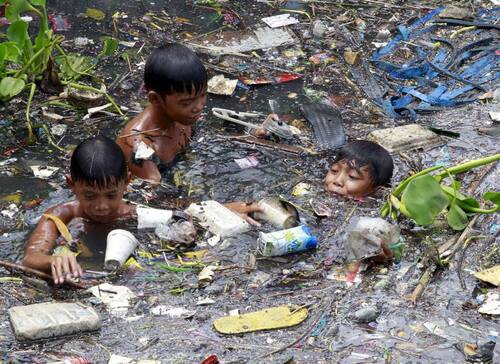 Des enfants au travail font les poubelles aux Philippines