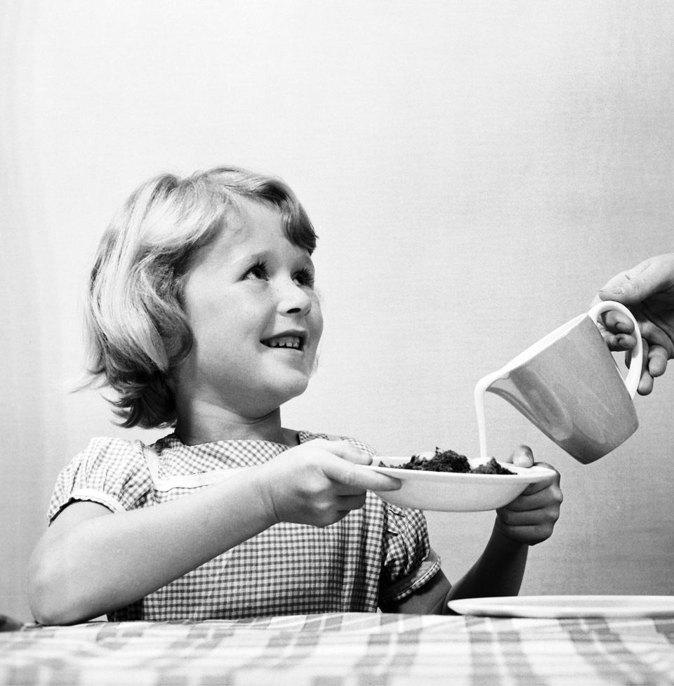 Une petite fille profite de son bol de céréales, le 6 août 1960.