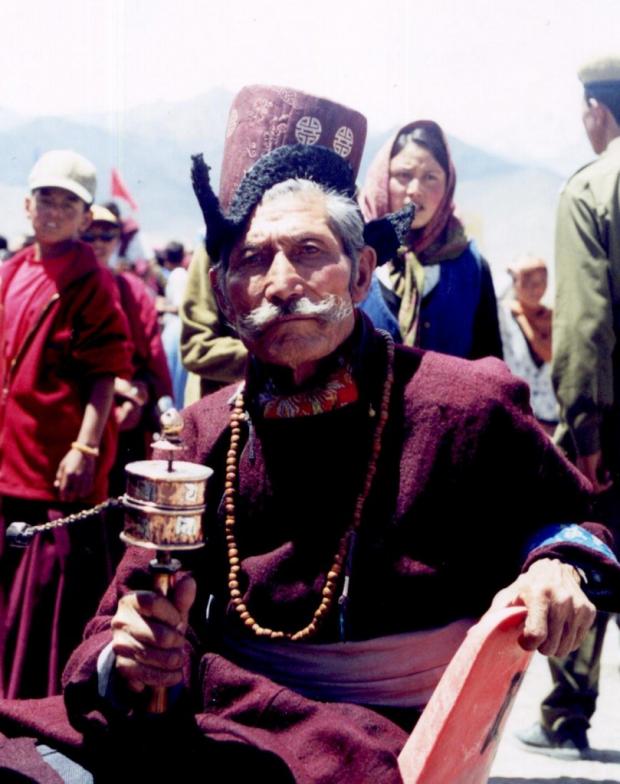 Viel homme et son moulin à prière attendant l'arrivée du premier ministre Indien.