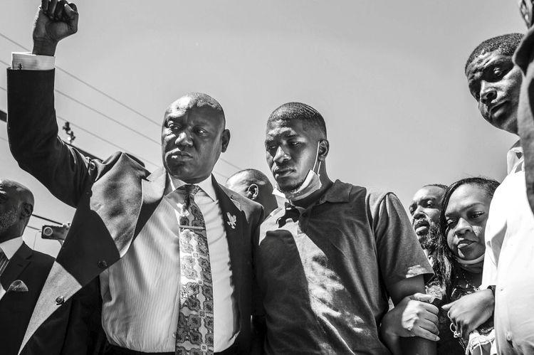 TOPSHOT - George Floyd's son, Quincy Mason Floyd (C R) and family Attorney Ben Crump (C L) and other family members visit on June 3, 2020, the site where George Floyd died in Minneapolis, Minnesota. (Photo by Kerem Yucel / AFP)