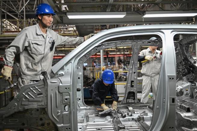 Des employés travaillent sur une ligne de production de véhicules électriques à l'usine Leapmotor de Jinhua, en Chine, le 18 septembre 2024