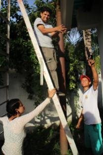 Odilio Mendez de la Comuna el Maizal, Rosana Melendez y un militante del Frente Francisco de Miranda instalan un sistema para recolectar la lluvia