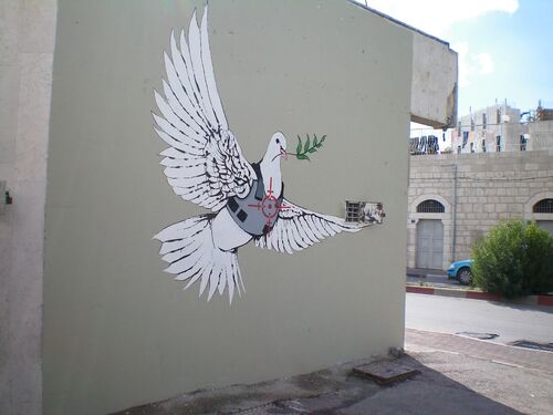 --- Banksy_2007--- Armoured_Peace_Dove ----- source : Wikipedia - image/photo pouvant être protégée par Copyright ou autre ----------------- Ce graffiti sur le mur de Bethléem (2007) marque l'endroit où plus de 40 hommes ont été tués pendant la première Intifada (les petits trous le long du sommet sont des impacts de balles) ---