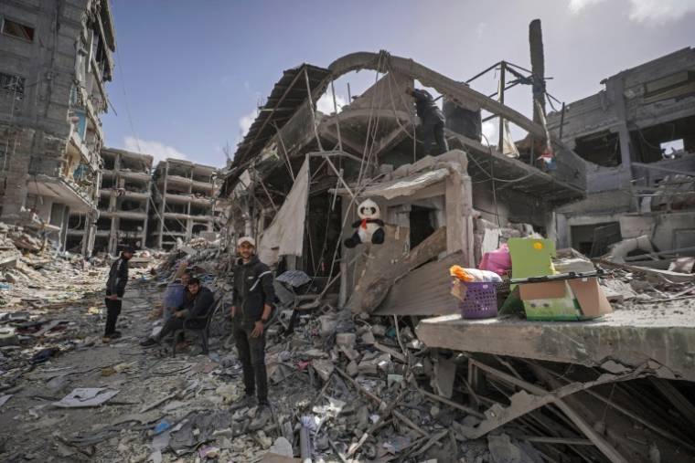 Des Palestiniens au milieu de décombres de bâtiments détruits par des bombardements israéliens, le 6 mars 2024 à Khan Younès, dans le sud de la bande de Gaza ( AFP / - )