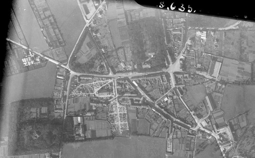 Outreau - Centre-ville en 1928, Église Saint-Wandrille et le cimetière à gauche, l'école à droite (remonterletemps.ign.fr)