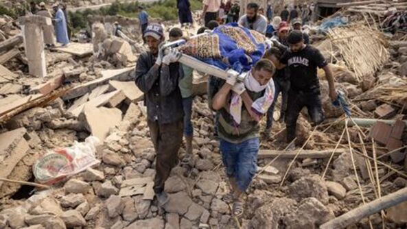 Des secouristes portent une victime décédée dans le séisme, à Imi N'Tala près d'Amizmiz, au centre du Maroc, le 10 septembre 2023. (FADEL SENNA / AFP)