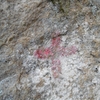 Rocher frontière avec une croix peinte en rouge
