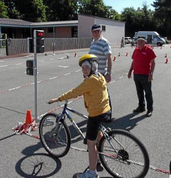 Exercice de circulation à vélo pour les CM1 sous l'oeil des deux gendarmes retraités de la prévention routière.