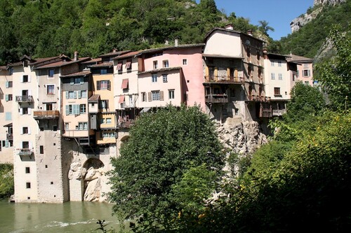 Les maisons accrochées à la falaise au dessus de la rivière "La Bourne".