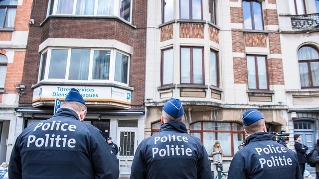 Trois officiers de police belges montent la garde dans la commune de Schaerbeek, dans la région de Bruxelles, le 25 mars 2016