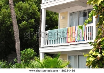 stock-photo-beach-towels-hanging-from-tropical-resort-balcony-railing-80724466