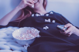 Une femme allongee et du popcorn