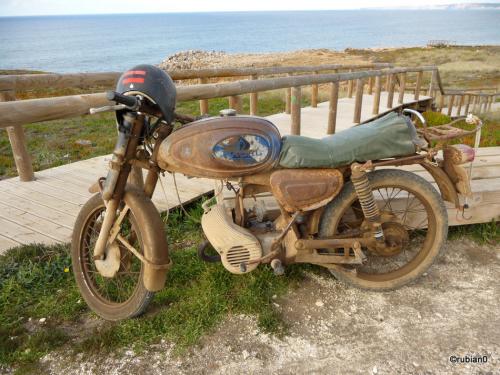 La moto de ce pêcheur a passé de longues heures au bord de l'océan.