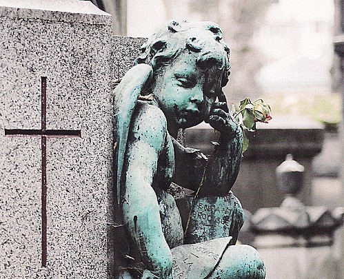 Petit ange sur une tombe au Père Lachaise (un visiteur lui