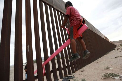 Children playing together on each side of  the Mexican Border ...