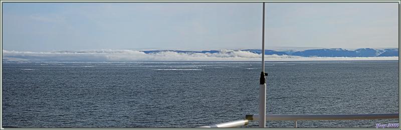 Le nord de la mer de Baffin est barrée par une épaisse brume rasante, les côtes du Groenland se profilent à l'horizon