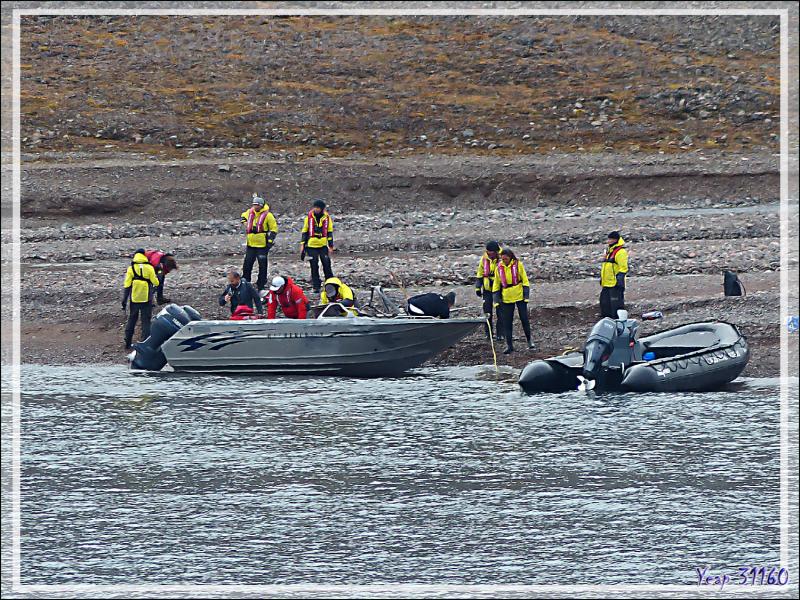 Au loin, en bordure de l'eau, une épave, c'est un bateau retourné en aluminum de type Harbercraft, équipé de deux moteurs - Guillemard Bay - Prince of Wales Island - Nunavut - Canada