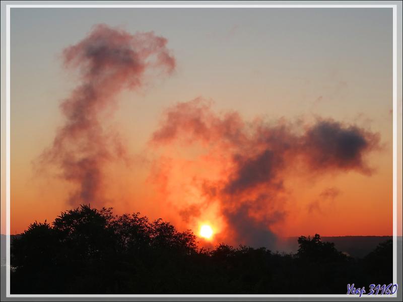 29 mars 2019 : au lever du soleil, la savane est en feu ! En réalité, ce sont les nuages formés par les chutes Victoria vues de notre hôtel - Victoria Falls - Zimbabwe