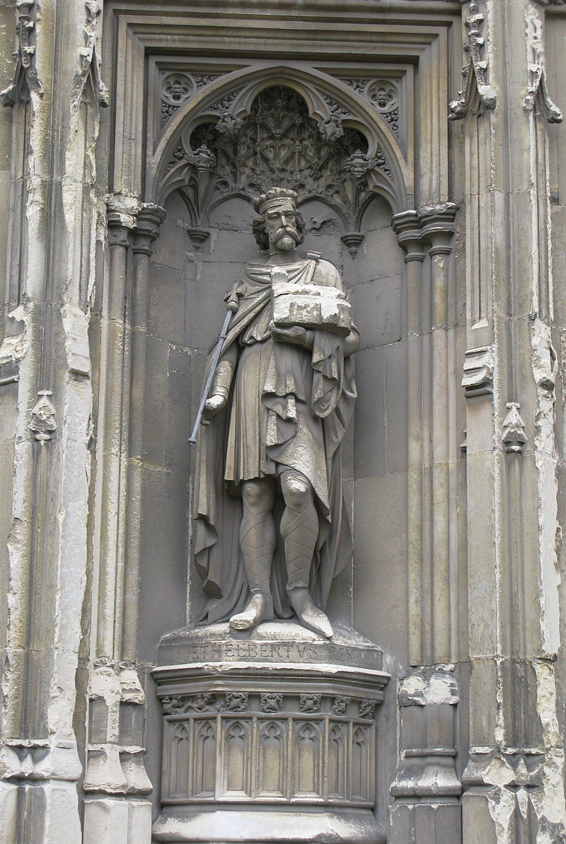 Photo de la statue d'un roi en pied, avec couronne et sceptre, pourtant une église symbole de sa fondation.